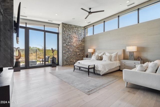 bedroom featuring multiple windows, access to outside, ceiling fan, and light hardwood / wood-style flooring