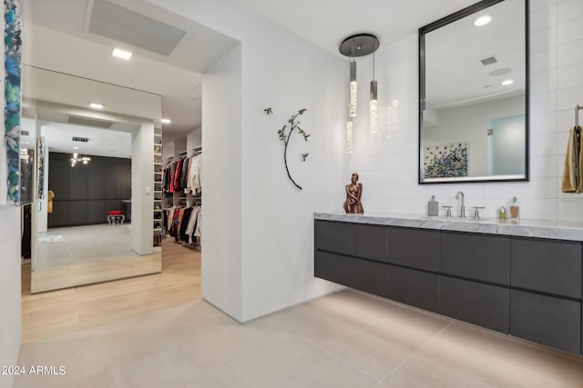 bathroom with vanity, hardwood / wood-style floors, and decorative backsplash