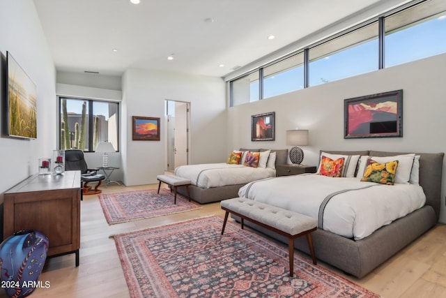 bedroom with light hardwood / wood-style floors and multiple windows