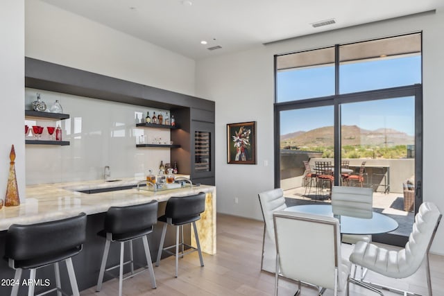 interior space with a mountain view, light hardwood / wood-style floors, and light stone counters