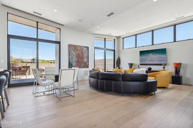 living room featuring light hardwood / wood-style flooring and a towering ceiling