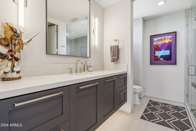 bathroom featuring vanity, toilet, and a shower with shower door