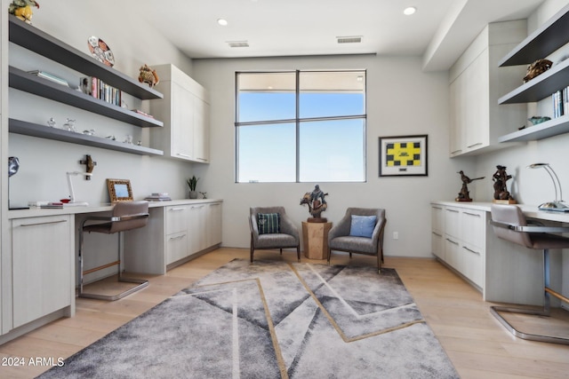 sitting room featuring built in desk and light hardwood / wood-style floors