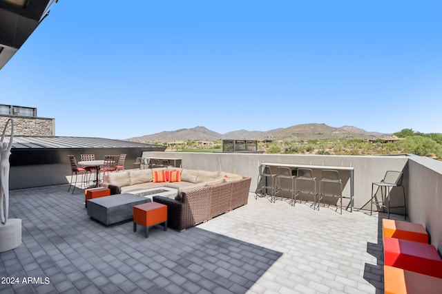 view of patio / terrace with a mountain view, an outdoor living space, and a bar