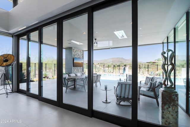 entryway with ceiling fan, floor to ceiling windows, and a healthy amount of sunlight