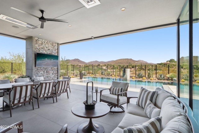 view of patio with ceiling fan, a mountain view, a fenced in pool, and an outdoor living space