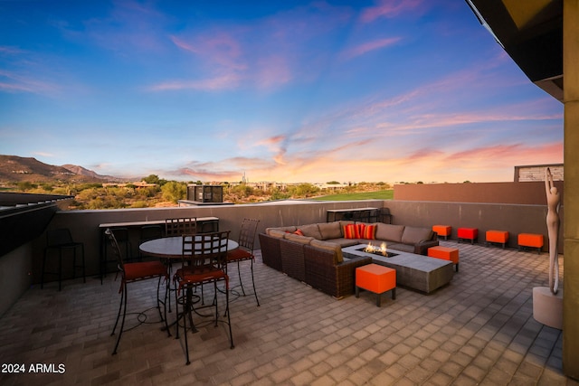 patio terrace at dusk featuring outdoor lounge area and a mountain view