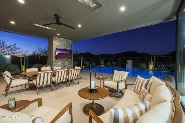 patio at twilight with an outdoor hangout area, a fenced in pool, and ceiling fan