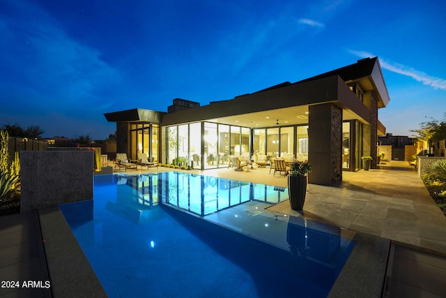 pool at dusk featuring a patio