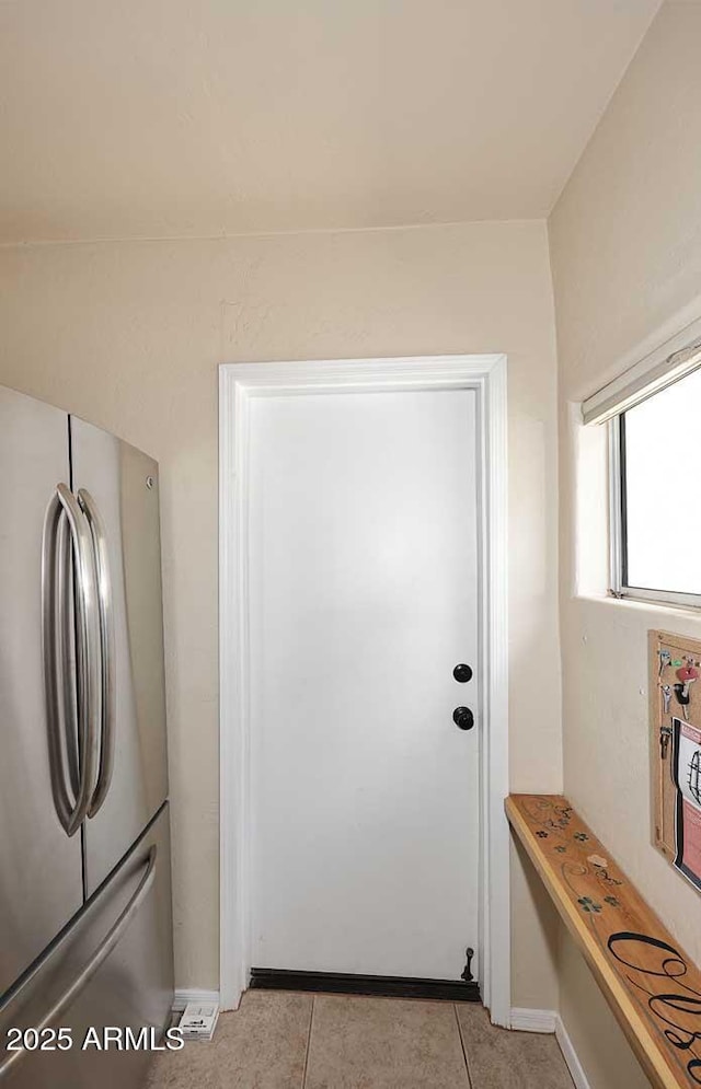 kitchen with baseboards, freestanding refrigerator, and light tile patterned floors
