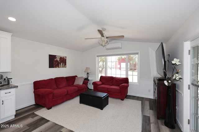 living room with a wainscoted wall, a wall mounted AC, vaulted ceiling, and dark wood-style flooring
