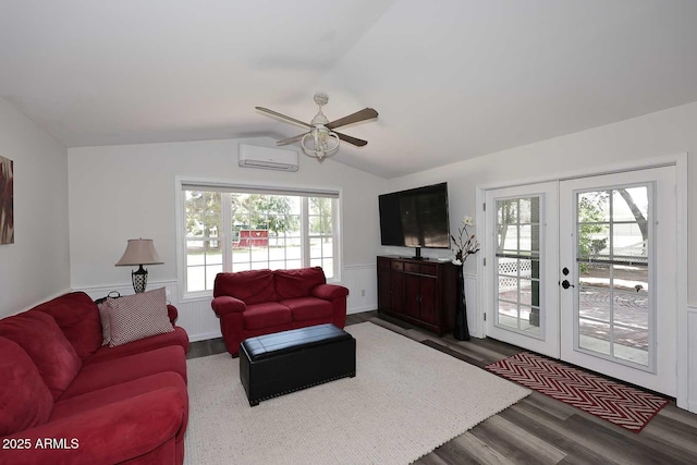 living room with a wall mounted air conditioner, french doors, a ceiling fan, vaulted ceiling, and dark wood-style floors