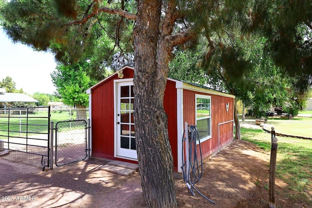 view of outbuilding featuring fence, a gate, and an outdoor structure