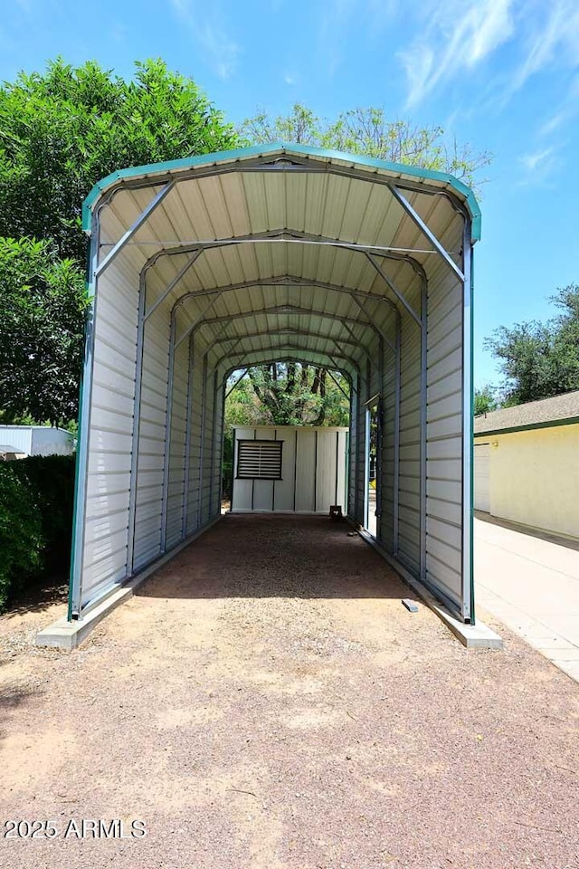 view of vehicle parking with driveway and a detached carport