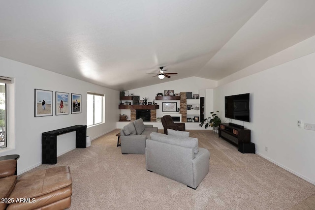 living area with light colored carpet, ceiling fan, lofted ceiling, and a stone fireplace