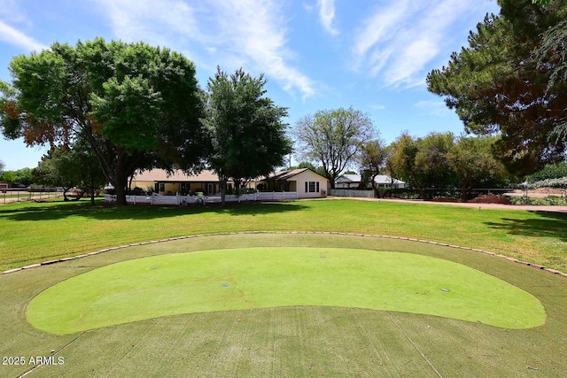 view of community featuring golf course view and a yard