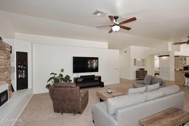 living room with light colored carpet, a ceiling fan, baseboards, lofted ceiling, and visible vents
