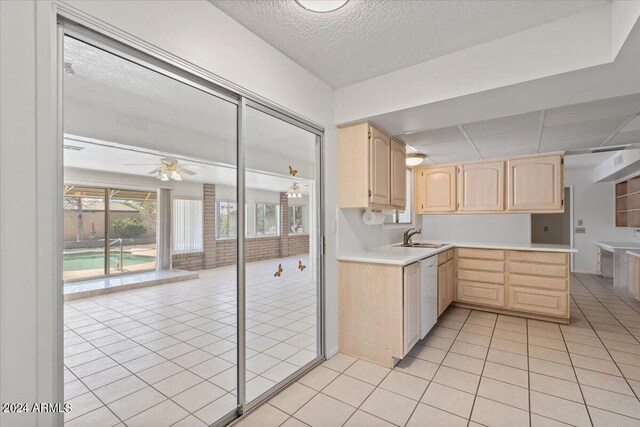 kitchen featuring white dishwasher, light brown cabinets, a drop ceiling, light tile patterned floors, and sink