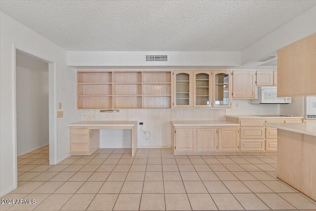 kitchen with ceiling fan, a textured ceiling, light brown cabinets, and light tile patterned floors