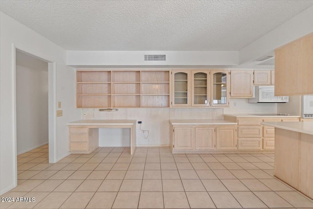 kitchen with black electric cooktop, light tile patterned floors, a textured ceiling, and light brown cabinets