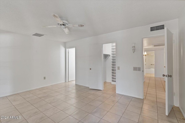 tiled empty room featuring a textured ceiling and ceiling fan