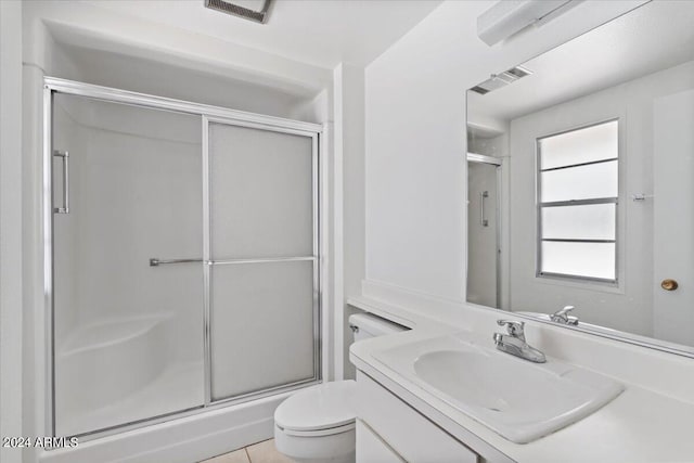 bathroom with vanity, a shower with door, and toilet