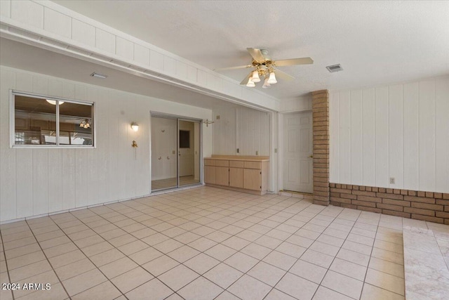 unfurnished room featuring light tile patterned floors, a textured ceiling, and ceiling fan