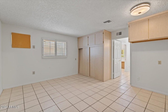 unfurnished room featuring light tile patterned floors and a textured ceiling