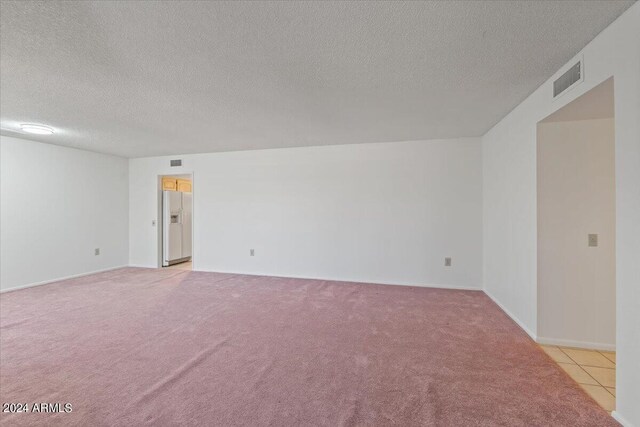 carpeted spare room featuring a textured ceiling