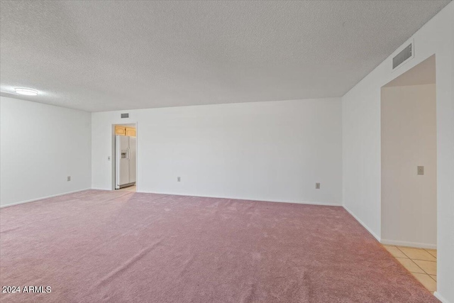 unfurnished room with light carpet and a textured ceiling