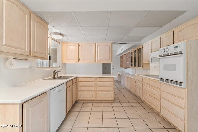 kitchen with white appliances, light carpet, and light brown cabinets