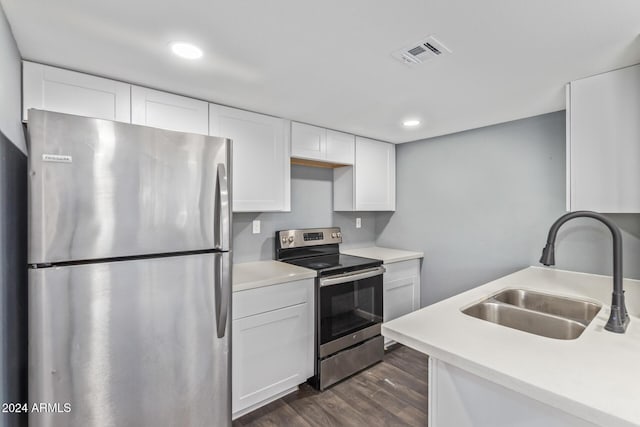 kitchen with sink, white cabinets, dark wood-type flooring, and appliances with stainless steel finishes