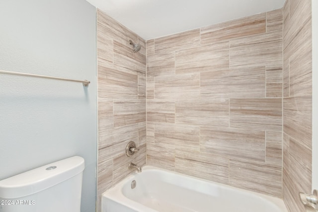 bathroom featuring toilet and tiled shower / bath