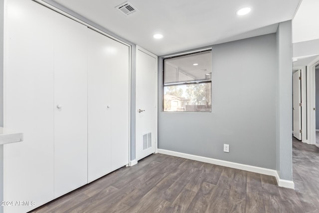 unfurnished bedroom featuring wood-type flooring and a closet