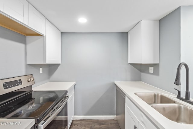 kitchen featuring appliances with stainless steel finishes, dark hardwood / wood-style flooring, white cabinetry, and sink