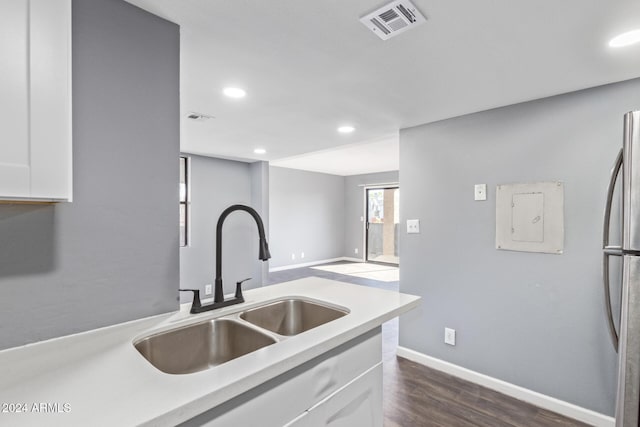 kitchen with stainless steel fridge, sink, electric panel, white cabinetry, and dark hardwood / wood-style floors