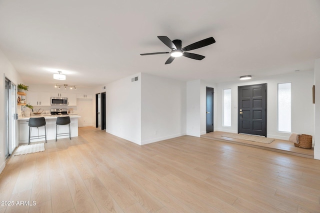 unfurnished living room with ceiling fan and light hardwood / wood-style floors