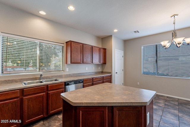 kitchen featuring stainless steel dishwasher, sink, hanging light fixtures, and a kitchen island