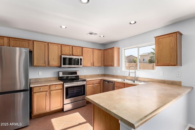 kitchen with stainless steel appliances, kitchen peninsula, sink, and light tile patterned floors