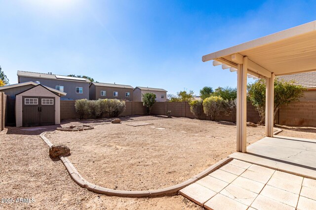 view of yard featuring a storage shed and a patio area