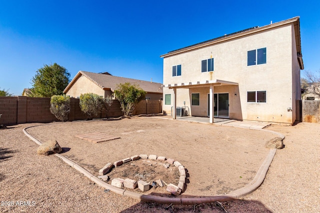 rear view of house with central AC unit and a patio area