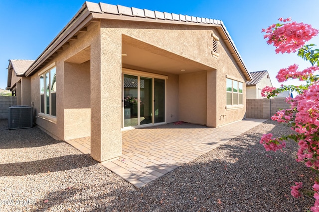 rear view of property featuring a patio and cooling unit