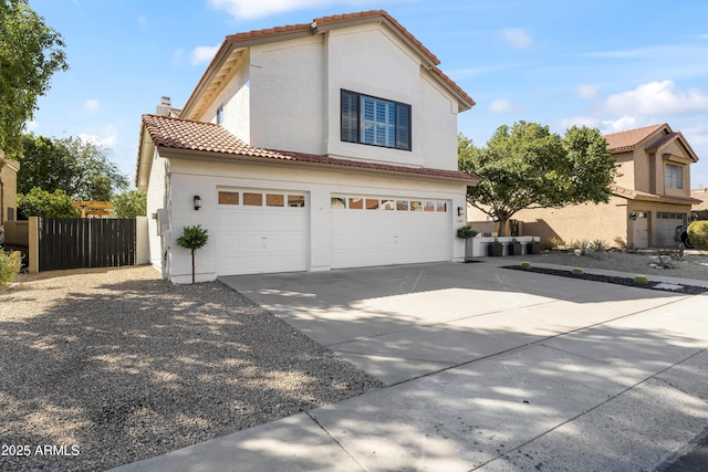 view of front of house with a tiled roof, concrete driveway, an attached garage, and stucco siding