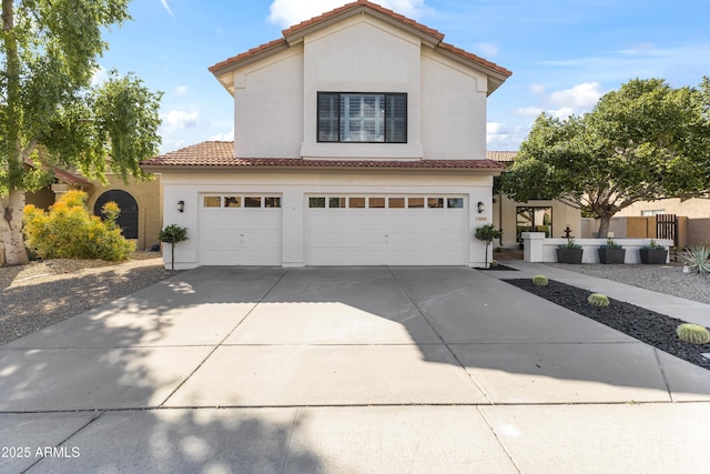 view of front facade with a garage, driveway, a tile roof, and stucco siding