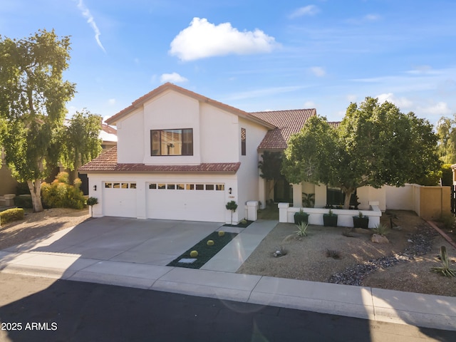 view of front of house with stucco siding, concrete driveway, an attached garage, fence, and a tiled roof