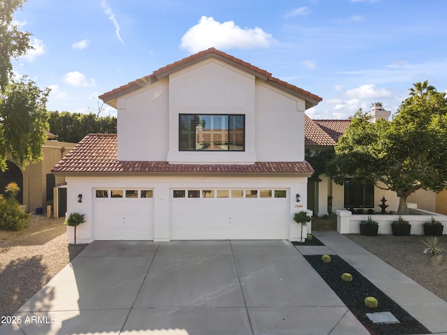 mediterranean / spanish-style home with a tiled roof, an attached garage, driveway, and stucco siding