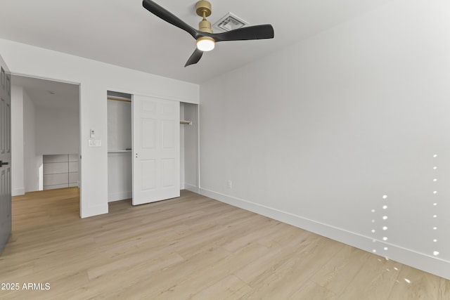 unfurnished bedroom featuring a closet, baseboards, visible vents, and light wood finished floors