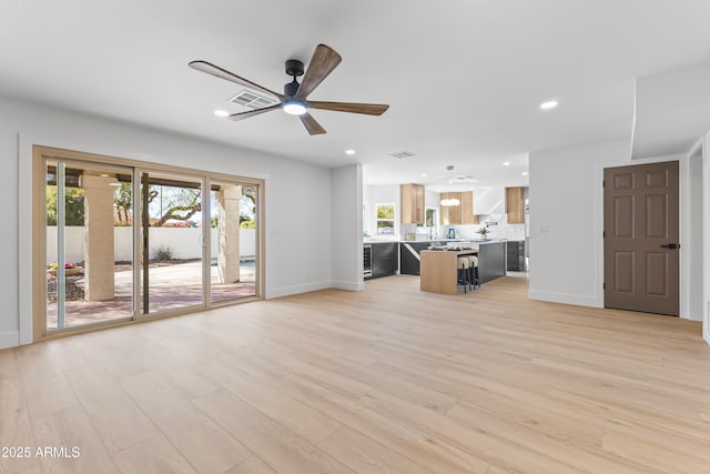 unfurnished living room featuring light wood-type flooring, visible vents, baseboards, and recessed lighting