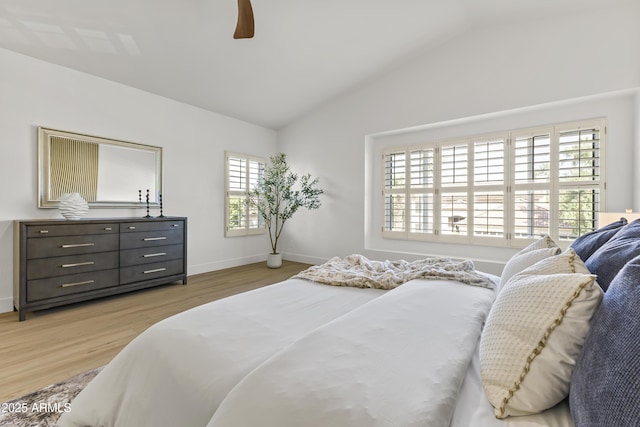 bedroom with light wood finished floors, baseboards, vaulted ceiling, and a ceiling fan