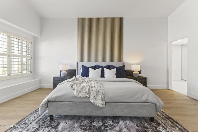 bedroom with baseboards and wood finished floors